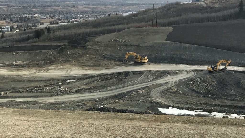 Looking east across the slope where excavators are preparing the area