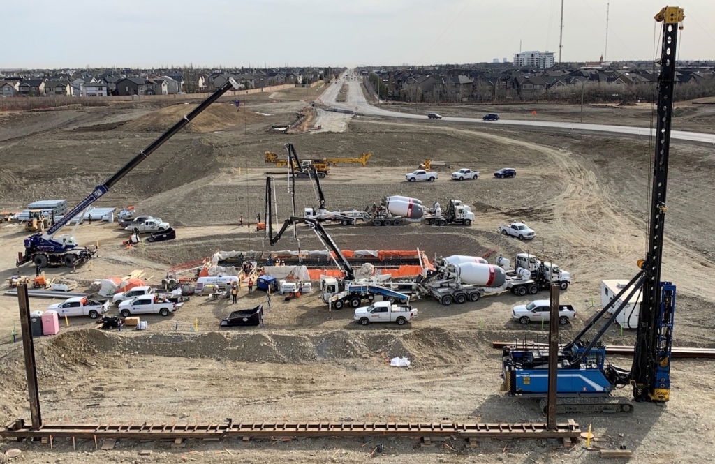 Looking east at Old Banff Coach Road S.W. interchange construction; in the centre of the photo the concrete pour for the centre pier footing is underway